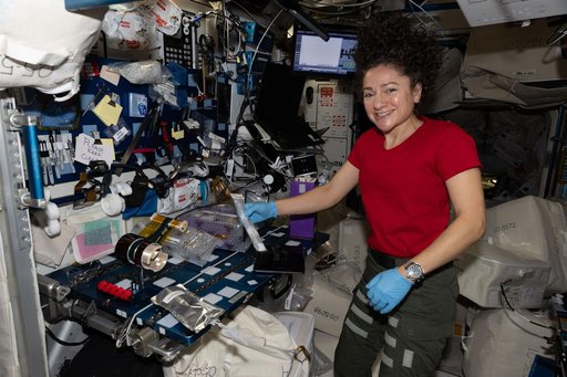 NASA astronaut Jessica Meir activates tubes filled with microbial and botanical samples