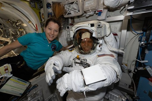 ESA astronaut Sophie Adenot assists NASA astronaut Chris Williams as he tries on his spacesuit