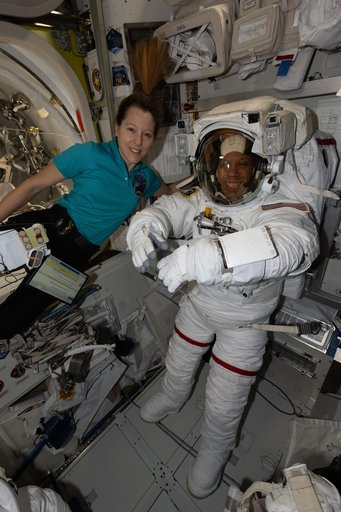 ESA astronaut Sophie Adenot assists NASA astronaut Chris Williams as he tries on his spacesuit