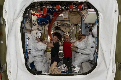 NASA astronauts Jessica Meir and Chris Williams prepare their spacesuits inside the Quest airlock