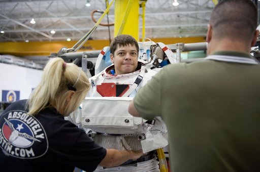 STS-130 crew members George Zamka, Steve Robinson helping Robert Behnken and Nick Patrick