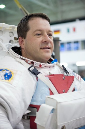 STS-130 crew members George Zamka, Steve Robinson helping Robert Behnken and Nick Patrick