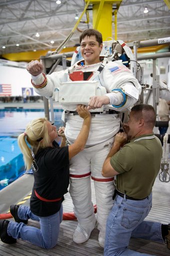 STS-130 crew members George Zamka, Steve Robinson helping Robert Behnken and Nick Patrick