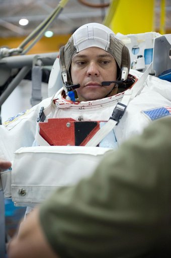 STS-130 crew members George Zamka, Steve Robinson helping Robert Behnken and Nick Patrick