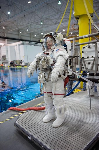 STS-130 crew members George Zamka, Steve Robinson helping Robert Behnken and Nick Patrick