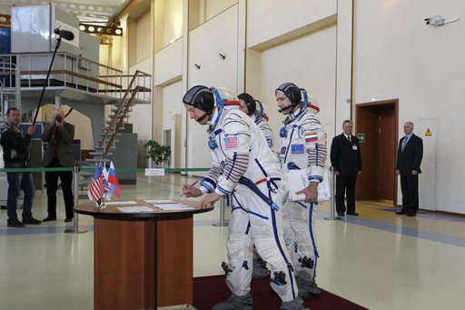 CG4G8721 --- (6 May 2015) --- At the Gagarin Cosmonaut Training Center in Star City, Russia, Expedition 44/45 backup Flight Engineer Timothy Kopra of NASA signs in for the first of two days of qualification exams May 6 as his crewmates, Yuri Malenchenko of the Russian Federal Space Agency (Roscosmos