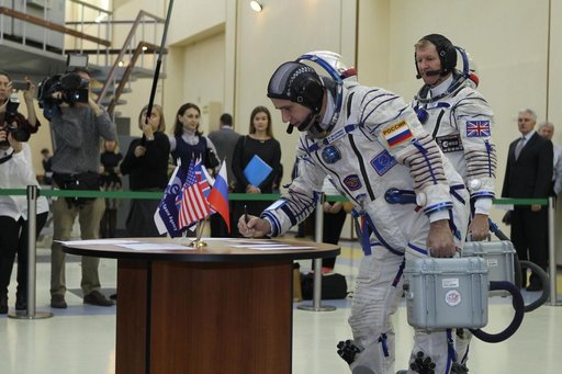 At the Gagarin Cosmonaut Training Center in Star City, Russia, Expedition 46-47 crewmember Yuri Malenchenko of the Russian Federal Space Agency (Roscosmos) signs in for his qualification exam Nov. 20 as his crewmate, Tim Peake of the European Space Agency looks on. Along with Tim Kopra of NASA, Male