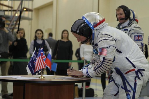 At the Gagarin Cosmonaut Training Center in Star City, Russia, Expedition 46-47 crewmember Tim Kopra of NASA signs in for his qualification exam Nov. 20 as his crewmate, Tim Peake of the European Space Agency looks on. Along with Yuri Malenchenko of the Russian Federal Space Agency (Roscosmos), Kopr