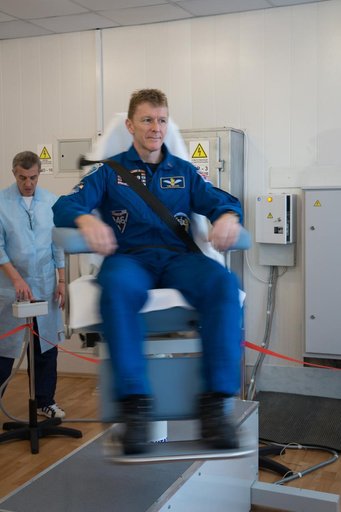 At the Cosmonaut Hotel crew quarters in Baikonur, Kazakhstan, Expedition 46-47 crewmember Tim Peake of the European Space Agency took a turn in a spinning chair to test his vestibular system Dec. 9 as part of his pre-launch training. Peake, Yuri Malenchenko of the Russian Federal Space Agency (Rosco