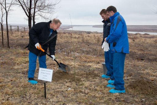 Behind the Cosmonaut Hotel crew quarters in Baikonur, Kazakhstan, Expedition 46-47 crewmember Tim Kopra of NASA (left) plants a tree at a site bearing his name Dec. 9 in a traditional pre-launch ceremony. Looking on are his crewmates, Tim Peake of the European Space Agency (center) and Yuri Malenche