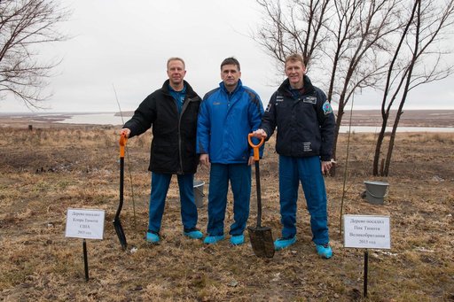 Behind their Cosmonaut Hotel crew quarters in Baikonur, Kazakhstan, Expedition 46-47 crewmember Tim Kopra of NASA (left), Yuri Malenchenko of the Russian Federal Space Agency (Roscosmos, center) and Tim Peake of the European Space Agency (right) pose for pictures Dec. 9 after a traditional tree-plan