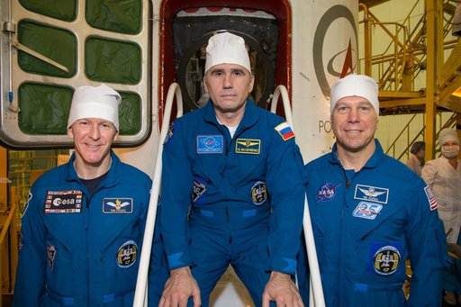 In the Integration Facility at the Baikonur Cosmodrome in Kazakhstan, Expedition 46-47 crewmembers Tim Peake of the European Space Agency (left), Yuri Malenchenko of the Russian Federal Space Agency (Roscosmos, center) and Tim Kopra of NASA (right) pose for pictures Dec. 10 during a final fit check 