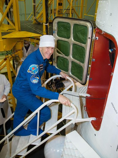 In the Integration Facility at the Baikonur Cosmodrome in Kazakhstan, Expedition 46-47 crewmember Tim Peake of the European Space Agency flashes a smile before entering his Soyuz spacecraft Dec. 10 during a final fit check and inspection. Peake, Tim Kopra of NASA and Yuri Malenchenko of the Russian 