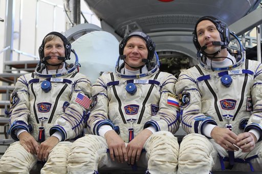At the Gagarin Cosmonaut Training Center in Star City, Russia, Expedition 48-49 backup crewmembers Peggy Whitson of NASA (left), Oleg Novitskiy of Roscosmos (center) and Thomas Pesquet of the European Space Agency (right) field questions from reporters in front of a Soyuz simulator during Soyuz qual