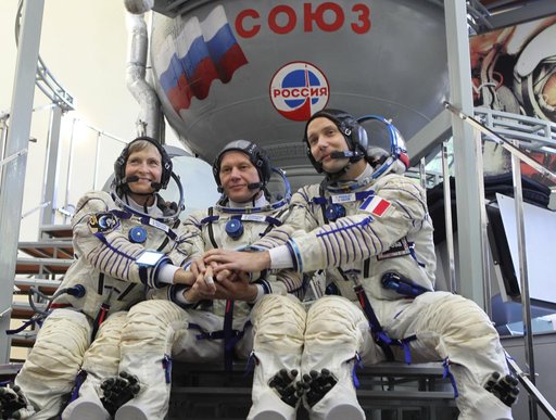 At the Gagarin Cosmonaut Training Center in Star City, Russia, Expedition 48-49 backup crewmembers Peggy Whitson of NASA (left), Oleg Novitskiy of Roscosmos (center) and Thomas Pesquet of the European Space Agency (right) pose for pictures in front of a Soyuz simulator during Soyuz qualification exa