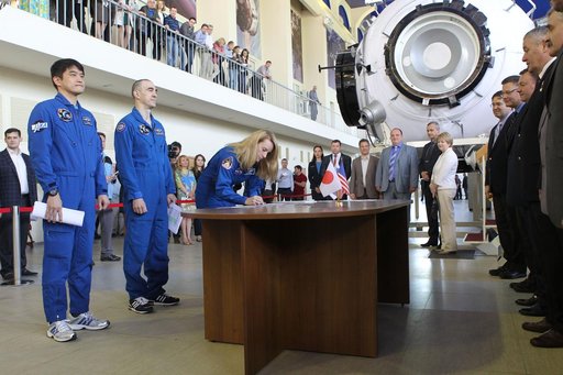 At the Gagarin Cosmonaut Training Center in Star City, Russia, Expedition 48-49 prime crewmember Kate Rubins of NASA signs in for the start of final qualification exams May 26 as her crewmates, Takuya Onishi of the Japan Aerospace Exploration Agency (left) and Anatoly Ivanishin of Roscosmos (center)