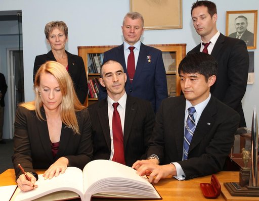 At the Gagarin Cosmonaut Training Center in Star City, Russia, Expedition 48-49 crewmember Kate Rubins of NASA (front row, left) signs a commemorative book May 31 following the crew���s news conference. Looking on are crewmates Anatoly Ivanishin of Roscosmos (front row, center) and Takuya Onishi of 
