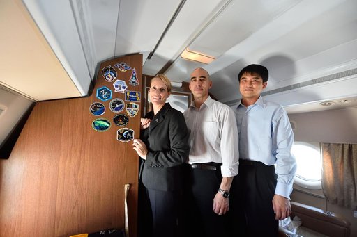 Aboard their aircraft en route to their launch site in Baikonur, Kazakhstan, ISS Expedition 48-49 crewmembers Kate Rubins of NASA (left), Anatoly Ivanishin of Roscosmos (center) and Takuya Onishi of the Japan Aerospace Exploration Agency (right) pose for pictures after affixing their mission insigni