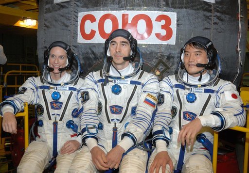In the Integration Facility at the Baikonur Cosmodrome in Kazakhstan, Expedition 48-49 crewmembers Kate Rubins of NASA (left), Anatoly Ivanishin of Roscosmos (center) and Takuya Onishi of the Japan Aerospace Exploration Agency (right) pose for pictures June 25 in front of the Soyuz MS-01 spacecraft 