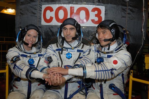 In the Integration Facility at the Baikonur Cosmodrome in Kazakhstan, Expedition 48-49 crewmembers Kate Rubins of NASA (left), Anatoly Ivanishin of Roscosmos (center) and Takuya Onishi of the Japan Aerospace Exploration Agency (right) pose for pictures June 25 in front of the Soyuz MS-01 spacecraft 