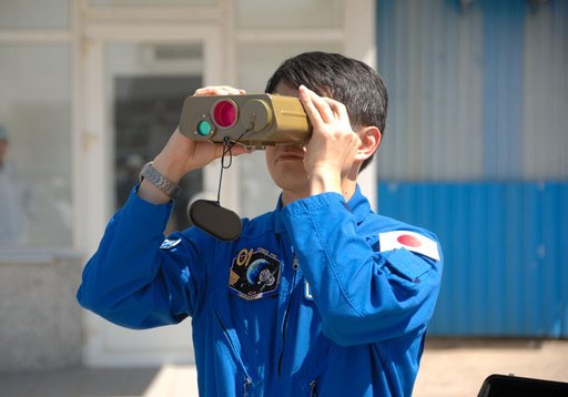 Outside the Integration Facility at the Baikonur Cosmodrome in Kazakhstan, Expedition 48-49 crewmember Takuya Onishi of the Japan Aerospace Exploration Agency tries out a pair of binoculars June 25 as he prepares for launch July 7, Baikonur time, on the Soyuz MS-01 spacecraft with Kate Rubins of NAS