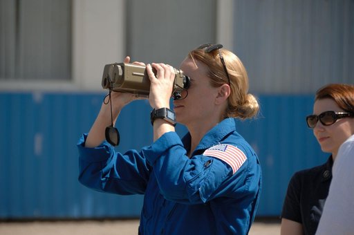 Outside the Integration Facility at the Baikonur Cosmodrome in Kazakhstan, Expedition 48-49 crewmember Kate Rubins of NASA tries out a pair of binoculars June 25 as she prepares for launch July 7, Baikonur time, on the Soyuz MS-01 spacecraft with Takuya Onishi of the Japan Aerospace Exploration Agen
