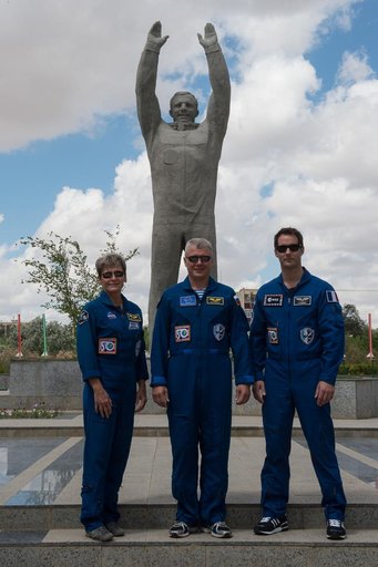 During a tour of the town in Baikonur, Kazakhstan June 26, Expedition 48-49 backup crewmembers Peggy Whitson of NASA (left), Oleg Novitskiy of Roscosmos (center) and Thomas Pesquet of the European Space Agency (right) pose for pictures in front of a statue of Yuri Gagarin, the first human to fly in 