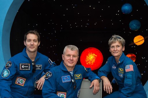 During a tour of a museum in Baikonur, Kazakhstan June 26, Expedition 48-49 backup crewmembers Thomas Pesquet of the European Space Agency (left), Oleg Novitskiy of Roscosmos (center) and Peggy Whitson of NASA (right) pose for pictures in front of a mural depicting planets. Whitson, Novitskiy and Pe