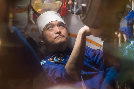 In the Integration Facility at the Baikonur Cosmodrome in Kazakhstan, Expedition 48-49 crewmember Takuya Onishi of the Japan Aerospace Exploration Agency conducts a �ޔfit check��� familiarization aboard the Soyuz MS-01 spacecraft June 25 as part of the preparations for launch with Anatoly Ivanishin 