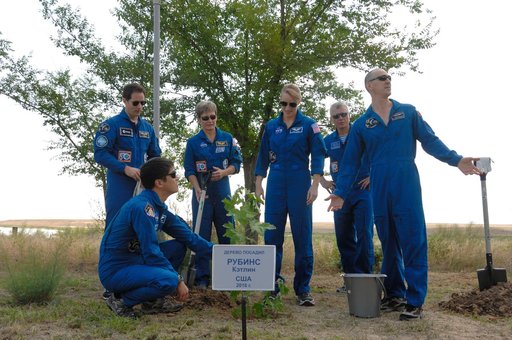 At the Cosmonaut Hotel in Baikonur, Kazakhstan, Expedition 48-49 crewmember Kate Rubins of NASA (third from left, standing) admires a tree she planted in her name in traditional pre-launch activities June 30 as her crewmates surround her. They include Takuya Onishi of the Japan Aerospace Exploration