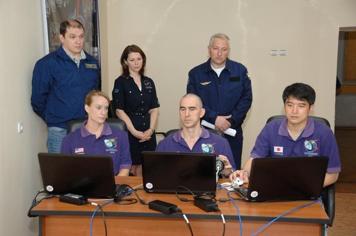 At the Cosmonaut Hotel in Baikonur, Kazakhstan, Expedition 48-49 crewmembers Kate Rubins of NASA (left), Anatoly Ivanishin of Roscosmos (center) and Takuya Onishi of the Japan Aerospace Exploration Agency (right) conduct rendezvous rehearsals on a laptop computer simulator June 30 as instructors loo