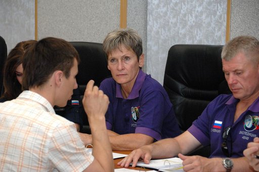 At the Cosmonaut Hotel in Baikonur, Kazakhstan, Expedition 48-49 backup crewmember Peggy Whitson of NASA listens to a rendezvous instructor June 30 as her crewmate, Oleg Novitskiy of Roscosmos (right) reviews documents. They are backups to the prime crewmembers, Kate Rubins of NASA, Anatoly Ivanishi