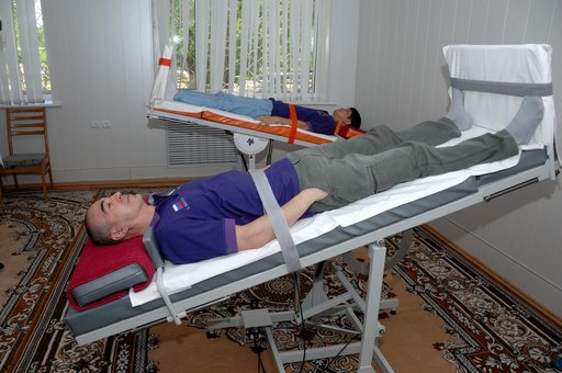 At the Cosmonaut Hotel in Baikonur, Kazakhstan, Expedition 48-49 crewmembers Anatoly Ivanishin of Roscosmos (foreground) and Takuya Onishi of the Japan Aerospace Exploration Agency conduct tests of their vestibular system on tilt tables June 30 as part of pre-launch activities. They and Kate Rubins 