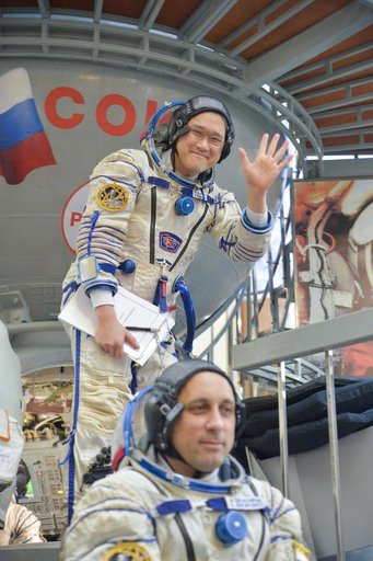 jsc2017e135210 - At the Gagarin Cosmonaut Training Center in Star City, Russia, Expedition 54-55 prime crewmember Norishige Kanai of the Japan Aerospace Exploration Agency (JAXA) waves to reporters as he boards a Soyuz spacecraft simulator Nov. 29 as part
