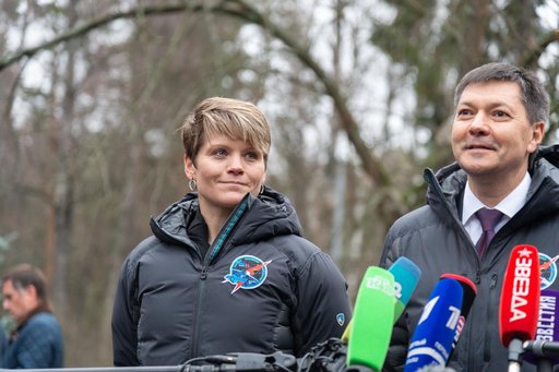 jsc2018e097268 - Expedition 58 crewmember Anne McClain of NASA (left) looks on as crewmate Oleg Kononenko of Roscosmos answer reporters’ questions Nov. 19 at the Gagarin Cosmonaut Training Center in Star City, Russia before boarding a plane to fly to th