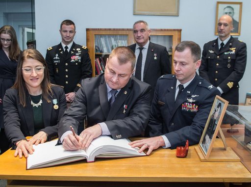 jsc2019e004424 - At the Gagarin Museum in the Gagarin Cosmonaut Training Center in Star City, Russia, Expedition 59 crewmembers Christina Koch of NASA (front, left), Alexey Ovchinin of Roscosmos (front, center) and Nick Hague of NASA (front, right) sign a