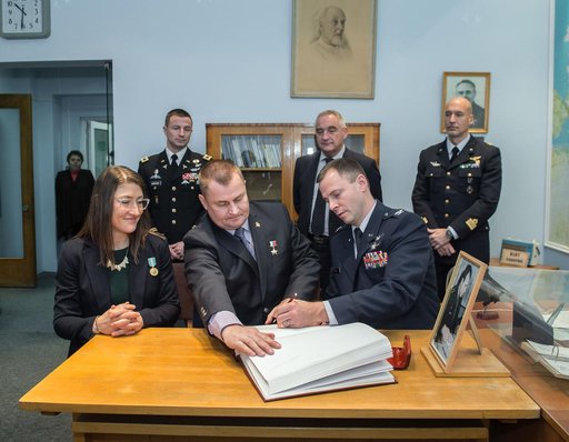 jsc2019e004425 - At the Gagarin Museum in the Gagarin Cosmonaut Training Center in Star City, Russia, Expedition 59 crewmember Nick Hague of NASA (front, right) signs a ceremonial book Feb. 21 as part of the crewâ€™s pre-launch activities as his crewmates