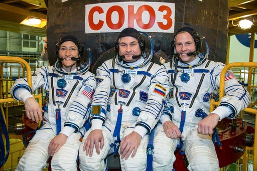 jsc2019e009956 - At the Baikonur Cosmodrome in Kazakhstan, Expedition 59 crewmembers Christina Koch of NASA (left), Alexey Ovchinin of Roscosmos (center) and Nick Hague of NASA (right) pose for pictures in front of their Soyuz MS-12 spacecraft Feb. 27 dur