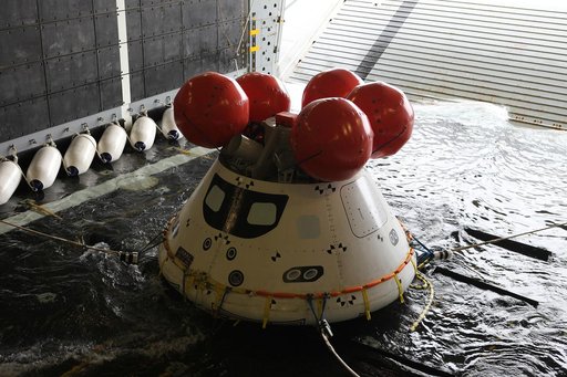 Recovery team members work with a test version of Orion floating in the well deck of the U.S.S. Anchorage