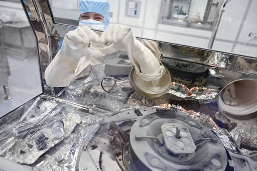 jsc2024e011323 - Astromaterials processor Mari Montoya shows a hand heart while working in the OSIRIS-REx canister glovebox at NASA’s Johnson Space Center in Houston. Montoya was sweeping asteroid material on the avionics deck of the OSIRIS-REx canister