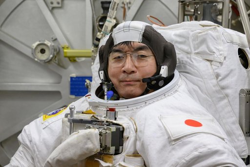 JAXA astronaut Kimiya Yui poses for a photo in his spacesuit