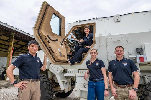 SpaceX Crew-10 members pose in front of their Mine Resistant Ambush Protected (MRAP) vehicle