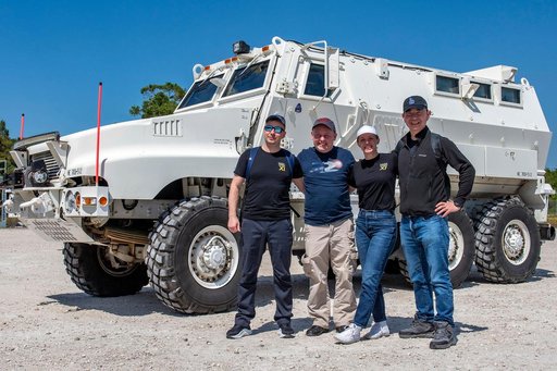 NASA's SpaceX Crew-11 members pose for a portrait by an emergency egress vehicle