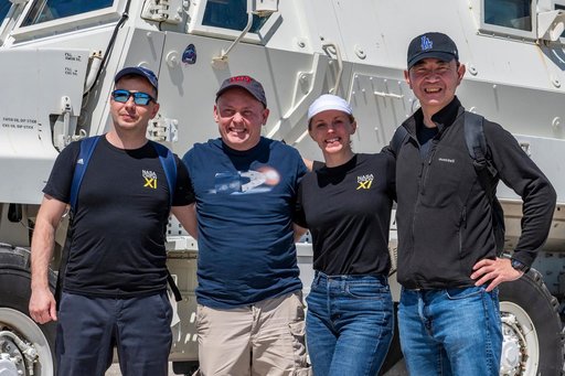NASA's SpaceX Crew-11 members pose for a portrait by an emergency egress vehicle