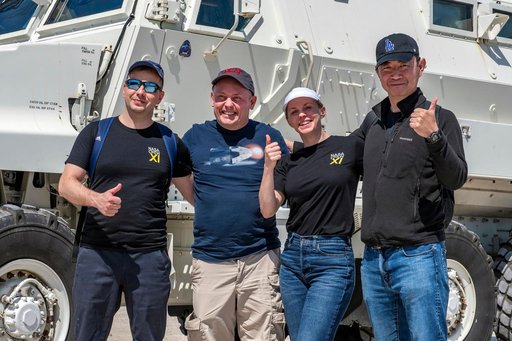 NASA's SpaceX Crew-11 members pose for a portrait by an emergency egress vehicle