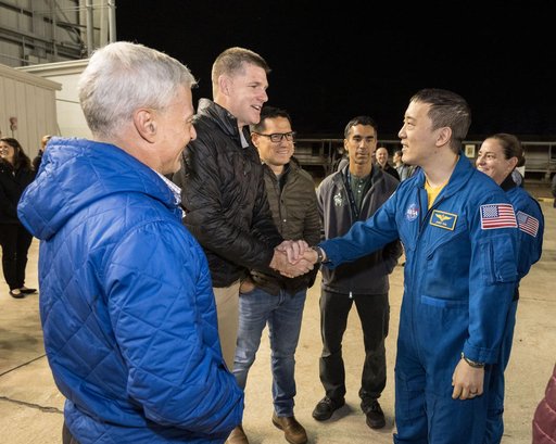 NASA astronaut Jonny Kim shakes the hand of Artemis II crew member Jeremy Hansen