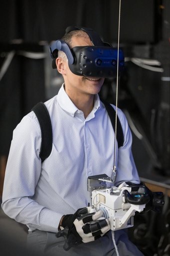 NASA astronaut Anil Menon wears virtual reality goggles for a spacewalk training session