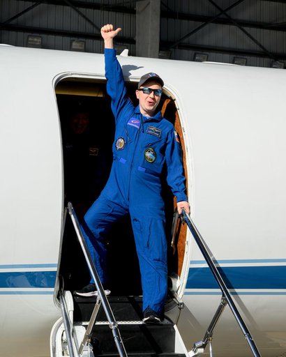 Roscosmos cosmonaut Oleg Platonov waves to officials at Ellington Field in Houston, Texas