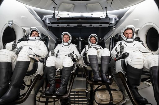 The SpaceX Crew-13 members are seated inside a mockup Dragon spacecraft