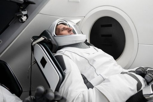 CSA astronaut Josh Kutryk is seated inside a mockup Dragon spacecraft